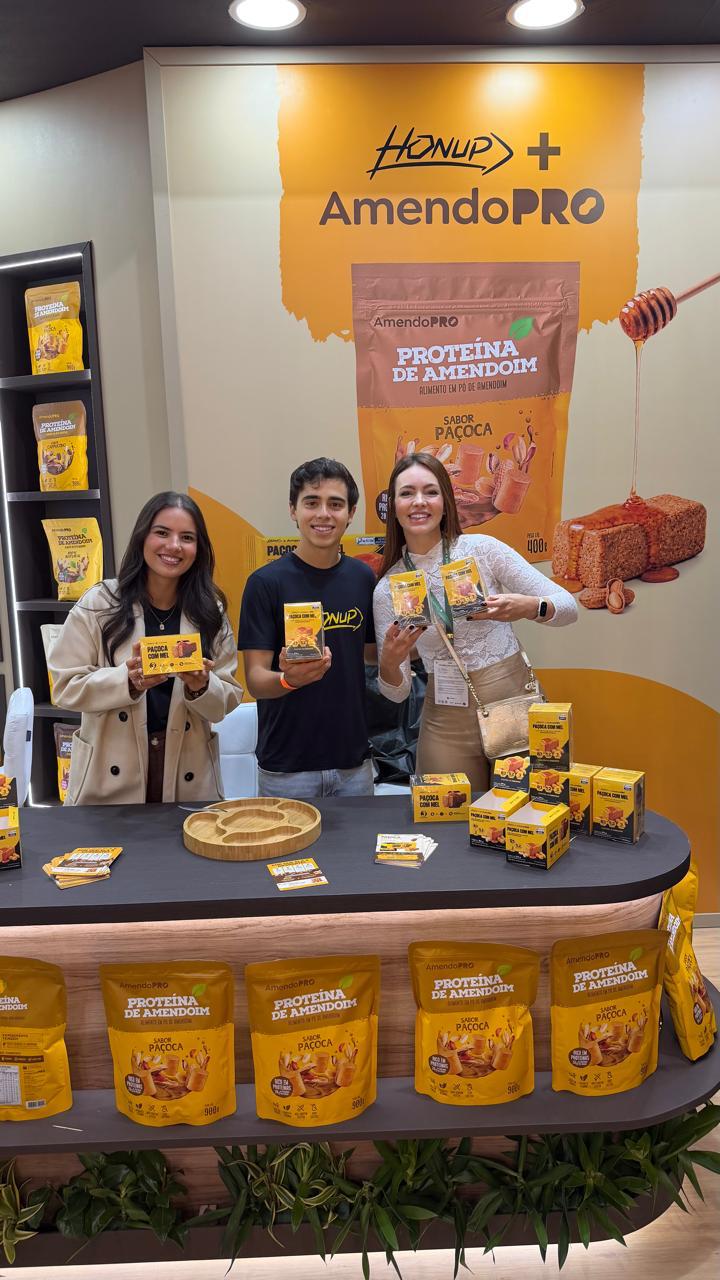Equipe Honup no estande da feira com produtos AmendoPRO